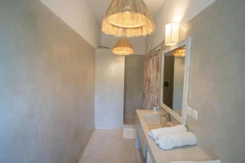 A bathroom lit by a woven lamp