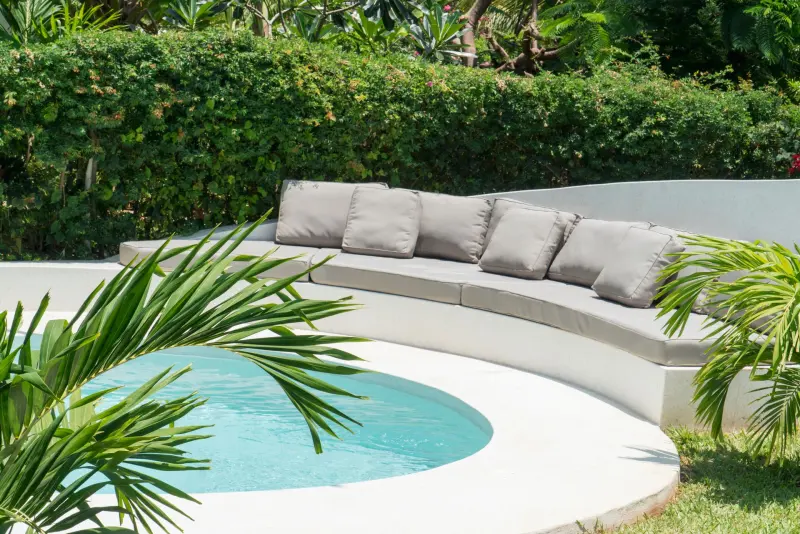 The cushioned pool deck framed by palms